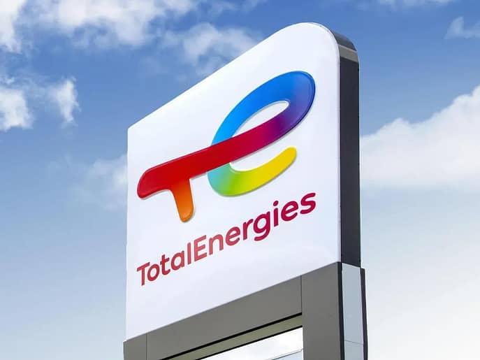 TotalEnergies billboard with a logo under a cloudy sky